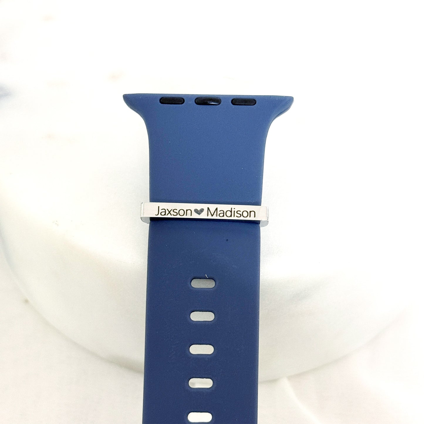 Personalized stainless steel watch band charm with custom engraving options, shown on a silicone watch band.