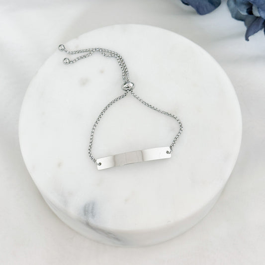 Personalized horizontal bar bracelet with bolo closure, adjustable to any wrist size, available in silver and gold finishes.