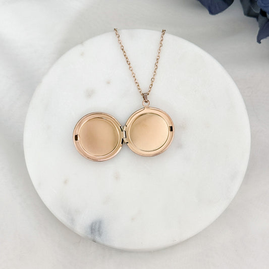 Large round locket necklace with customizable engraving options for names and dates, opened. 