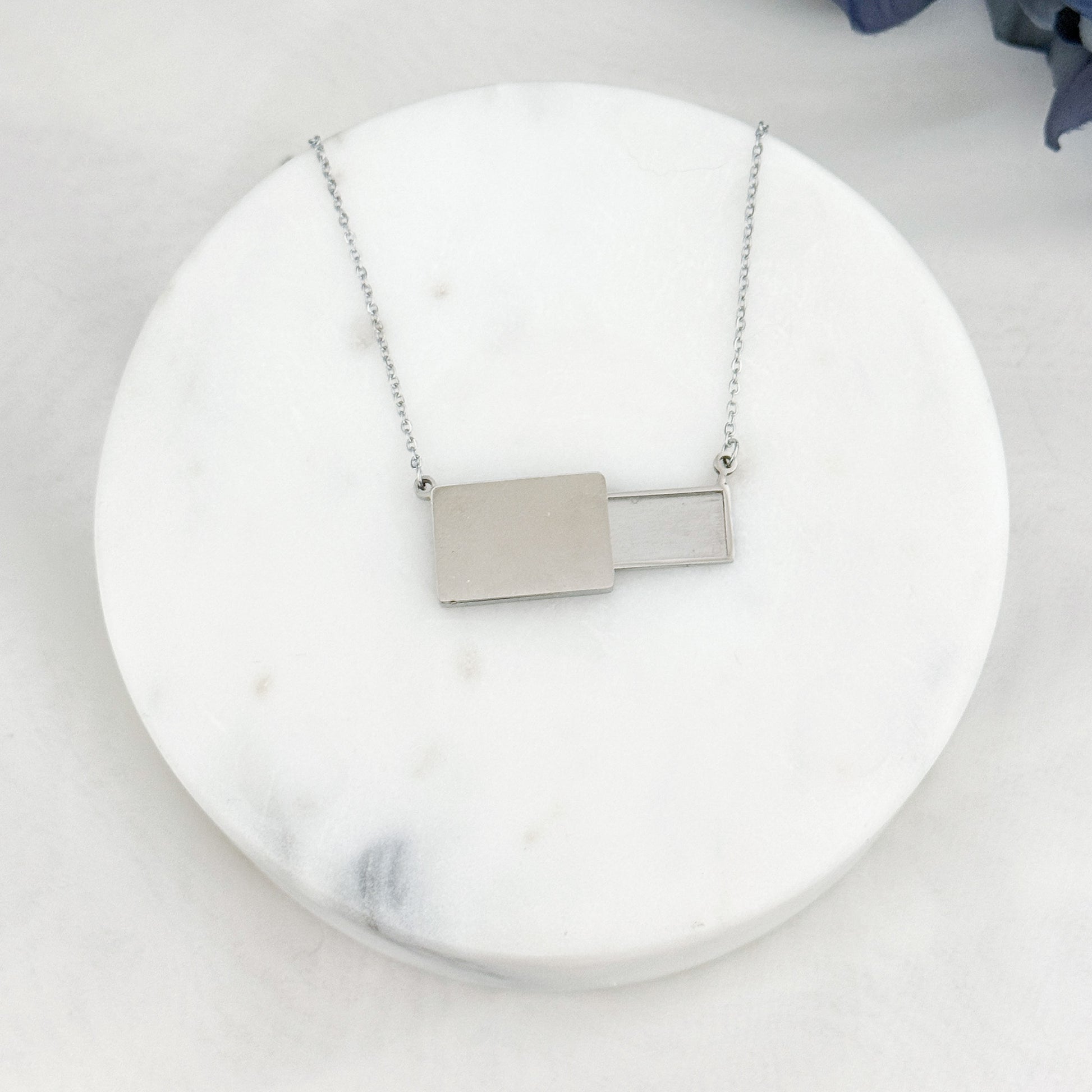 Veiled postcard necklace with hidden postcard, able to showcase customizable engravings and inclusions.