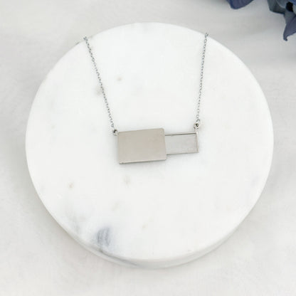Veiled postcard necklace with hidden postcard, able to showcase customizable engravings and inclusions.